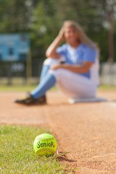 a tennis ball sitting on the ground next to a woman