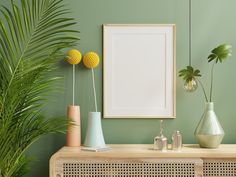 a green wall with some plants and vases on the table - stock photo - images