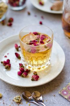 a glass filled with tea sitting on top of a white plate