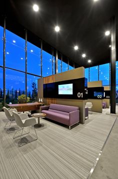 a living room filled with furniture next to large window covered in bright blue sky lights