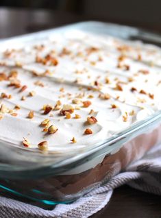 a glass dish filled with white frosting and chopped nuts