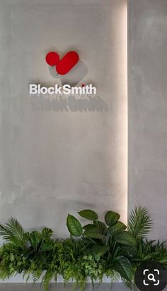 a planter filled with lots of green plants next to a sign that says blacks smith