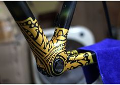 the handlebars on this bike are decorated with gold and black designs, along with a blue towel