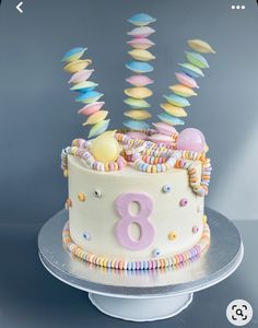 there is a birthday cake with candles in the shape of an eight on top and colorful icing