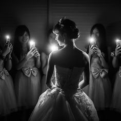 the bride is looking at her reflection in the mirror while she holds up two candles