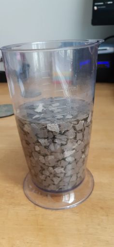 a plastic cup filled with rocks on top of a wooden table