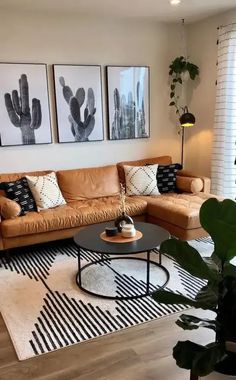 a living room with two couches, a coffee table and three pictures on the wall