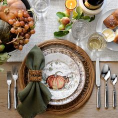 a table set with plates, silverware and napkins for thanksgiving or fall dinner