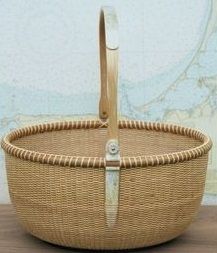 an empty wicker basket with handles on a table