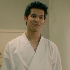 a man in a white kimono is looking at the camera