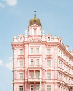 an old pink building with a clock on the top