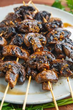 several skewers of food on a white plate