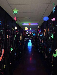 the hallway is decorated with stars and streamers on black walls, along with colorful lights