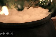 a pot filled with white foam next to a christmas tree