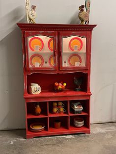 a red hutch with plates and bowls on it