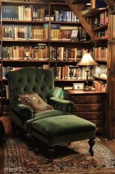 a green chair sitting in front of a book shelf filled with books