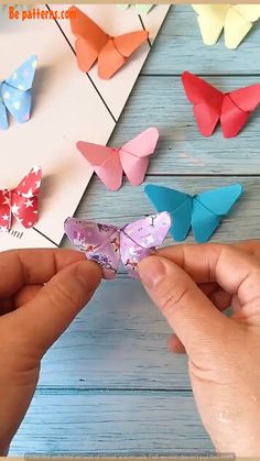 someone is making origami butterflies out of paper