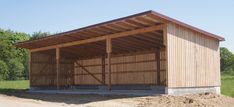 a large wooden building sitting on top of a dirt field