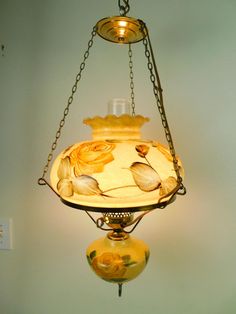 a lamp hanging from the ceiling with flowers on it