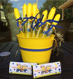 a yellow bucket filled with lots of yellow plastic utensils sitting on top of a table