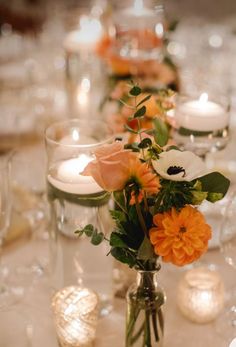 a long table with candles and flowers in vases on top of the tables is set for an event