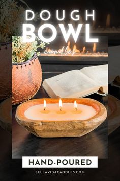 a lit candle sitting on top of a wooden bowl