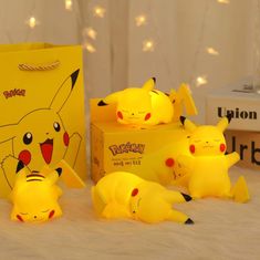 the pokemon pikachu lamp is next to its box and some other items in front of it