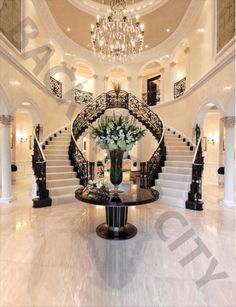 an elegant foyer with chandelier and marble flooring is featured in this photo