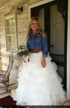 a woman in a white wedding dress standing on the front porch with her hand in her pockets