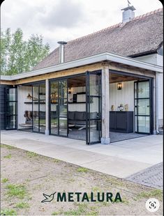 a small building with glass doors on the front and side windows, in an open area