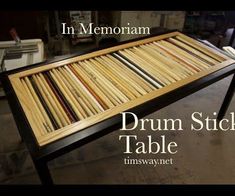 a table made out of wooden sticks with the words drum stick table in front of it