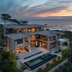 this is an aerial view of a large house by the ocean at sunset or dawn