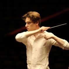 a young man holding a violin in his right hand