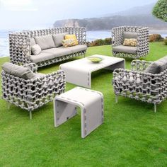 an outdoor furniture set sitting on top of a lush green field