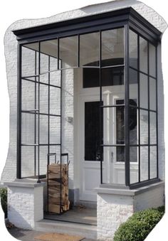 a white brick building with glass windows and a wooden crate in front of the door