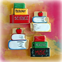 three cookies decorated with books and an apple on top of each cookie is reading music