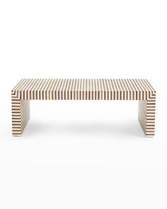 a wooden bench sitting on top of a white floor covered in brown and white stripes