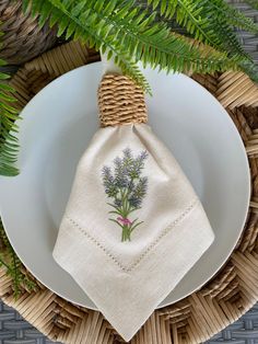 a white plate topped with a napkin next to a plant