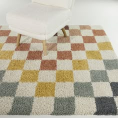 a white chair sitting on top of a checkered rug