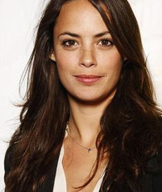 a woman with long brown hair wearing a black blazer