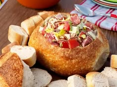 bread with meat and vegetables in it on a wooden table next to other breads