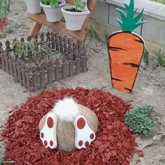 a carrot shaped planter sitting on top of a pile of wood shavings