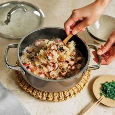 someone is stirring food in a pot on the table