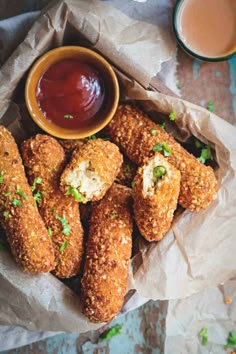 some fried food is in a basket with dipping sauce