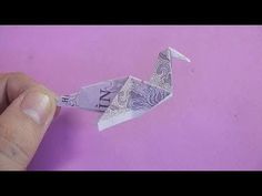 a person is holding an origami bird on a purple background with the word love written in it