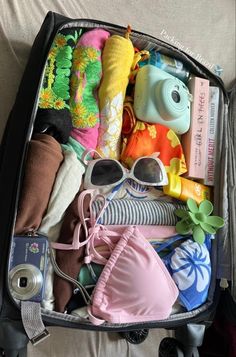 an open suitcase filled with clothing and toys