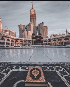 an open area with a book on the ground and buildings in the background at dusk