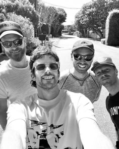 three men are taking a selfie on the street