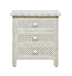 a white chest with two drawers and an intricate design on the front, one drawer is open