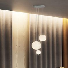 three lights hanging from the ceiling in a room with wood paneling on the walls